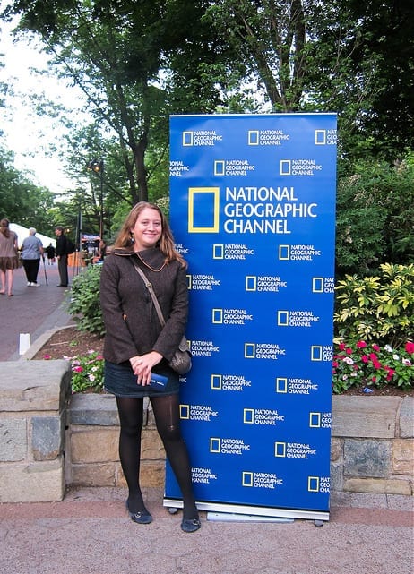 Me in Front of a National Geographic Sign - Should You Start a Travel Blog: The Dirty Truth