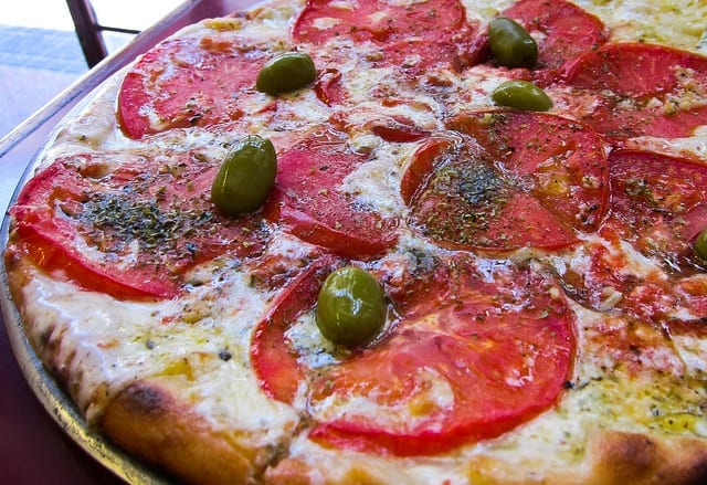 Pizza with tomatoes and olives in Buenos Aires - How to Eat Well on a Small Budget
