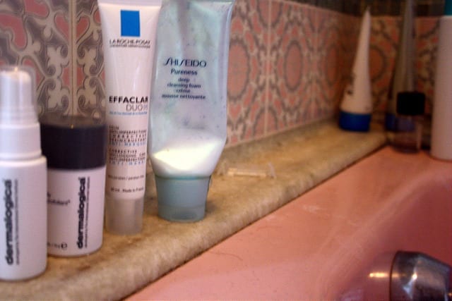 Skincare Products on the bathroom counter - How to Create a Travel Skincare Routine for Long Term Travel