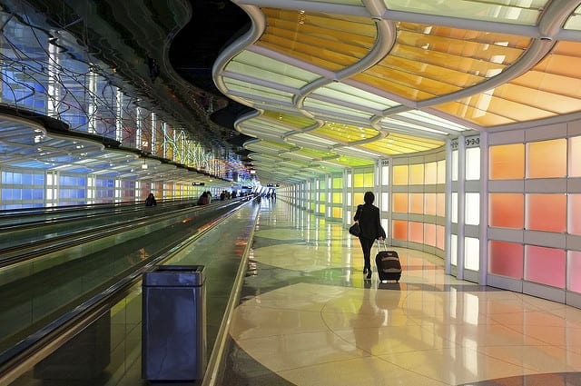 The Colorful Interior of an Airport with a Woman Walking Alone with her Bag - How to Survive a Long Flight