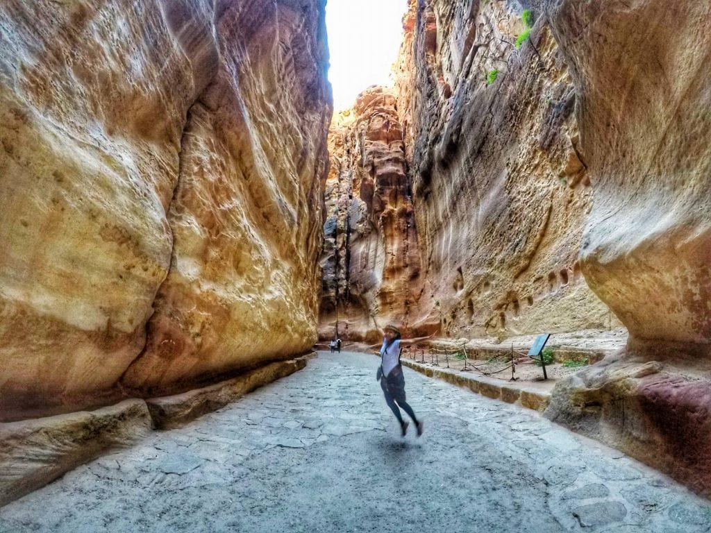 A Girl Jumping at the Entrance to Petra - The Siq or Gate to Begin Your Trip to Visit Petra