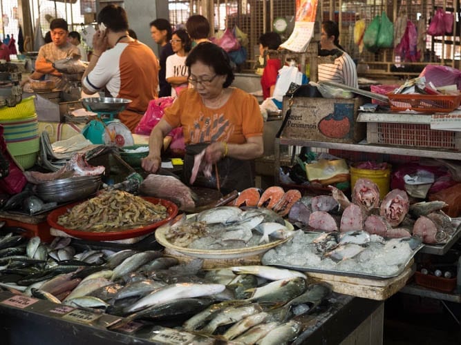 A Woman Gutting a Fish in the Market in Penang - A Luxury Malaysia Holiday